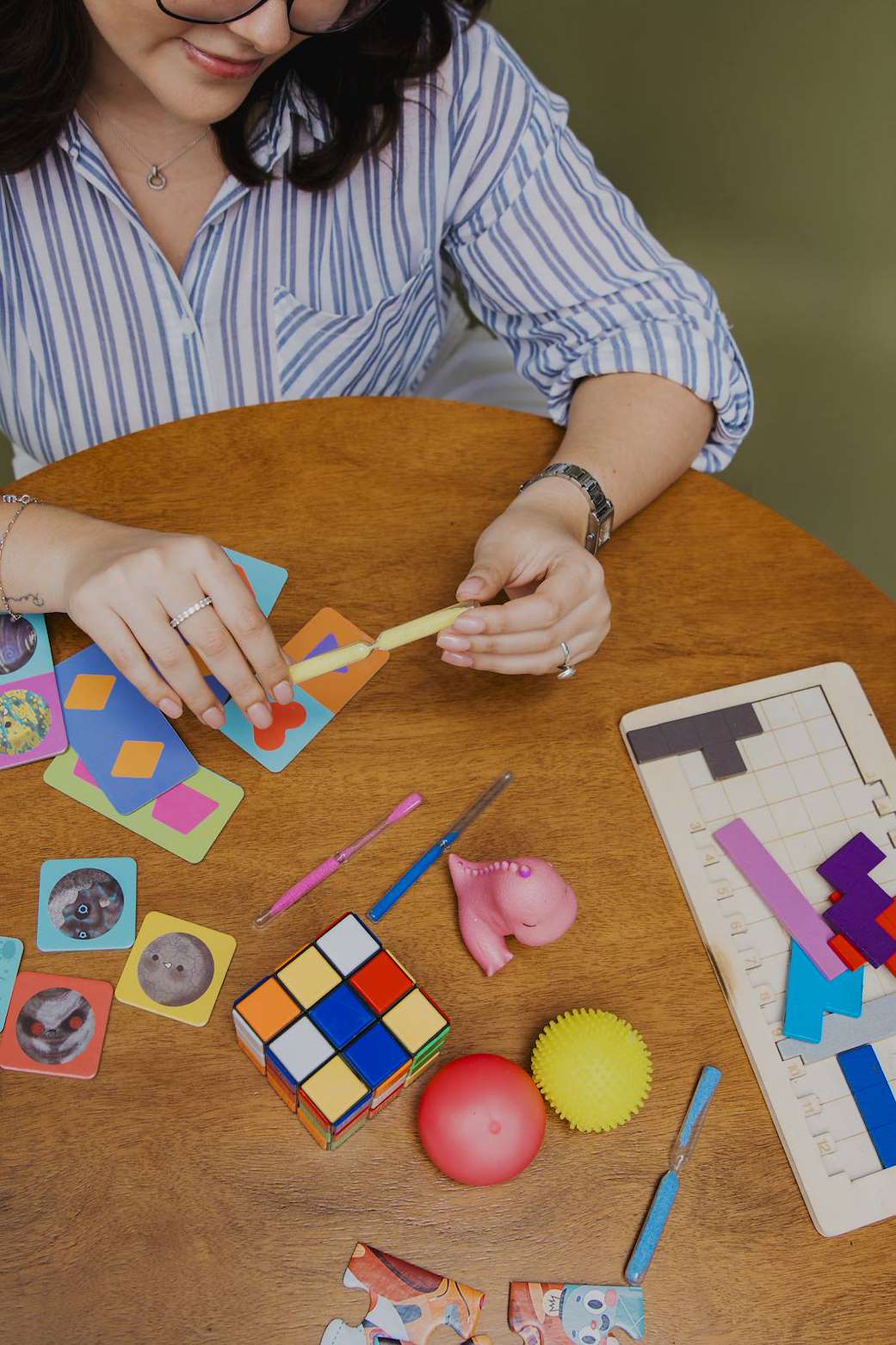 Materiales de estimulación cognitiva sobre la mesa: cartas, cubo de Rubik y rompecabezas